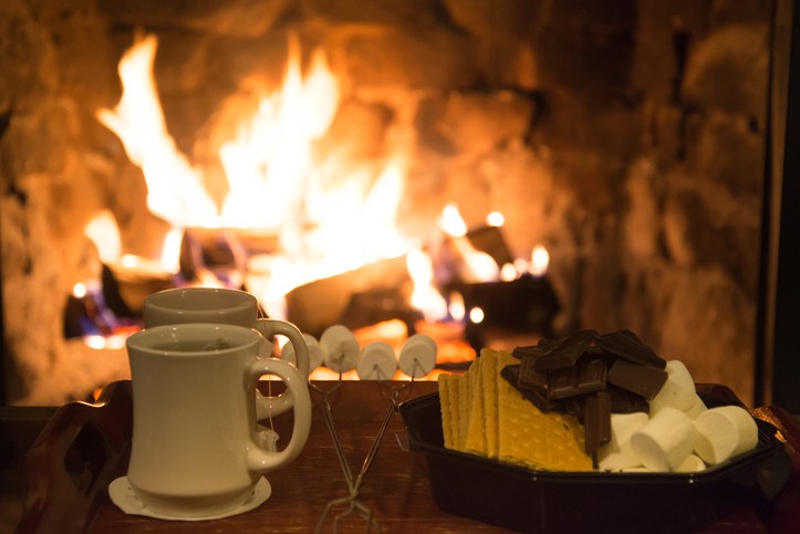 Smores treats and hot tea in front of a fireplace